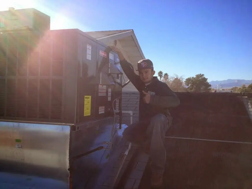 HVAC technician performing AC Tune-Up on a rooftop unit in Chehalis